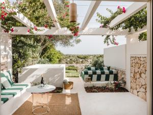 un patio con fiori e mobili verdi e bianchi di Hotel Rural Morvedra Nou a Ciutadella