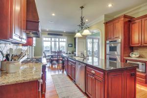 a large kitchen with wooden cabinets and a large island at Riverfront North Augusta Home with Private Pool! in North Augusta