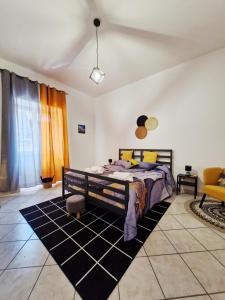 una camera con letto e sedia gialla di Casa Imma a Napoli