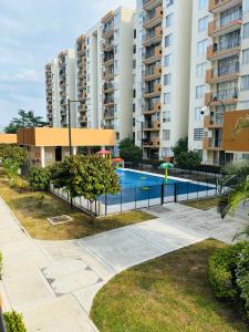 a swimming pool in front of some tall buildings at Espectacular Apartamento in Ricaurte