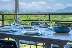 una mesa con copas de vino y un bol en el balcón en Séquoia furnished apartment en Antibes