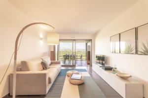 a living room with a couch and a tv at Séquoia furnished apartment in Antibes