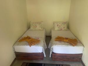 two twin beds in a corner of a room at Pousada Meraki Paraty Mirim in Paraty