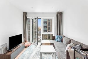 a living room with a couch and a large window at Stylish Flat In Battersea Reach in London