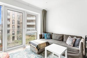 a living room with a couch and a large window at Stylish Flat In Battersea Reach in London