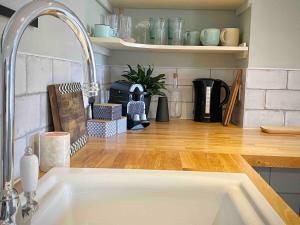 a kitchen counter with a sink in a kitchen at Georgian Loft Apartment - Central Bath in Bath