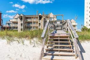 a wooden playground on the beach in front of a house at Seaside Sunrise Sanctuary in Carolina Beach