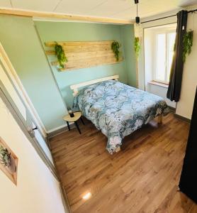 a bedroom with a bed and a wooden floor at La piscine en prairie in Saint-Amarin