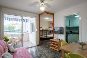 Las CanterasにあるApartamento en complejo residencial con piscina y garaje a 100m del marのリビングルーム(ソファ、テーブル付)、バルコニーが備わります。