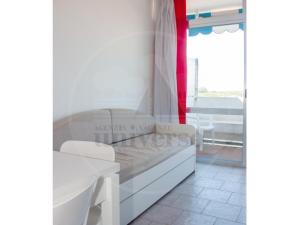 a bedroom with a bed and a table and a window at Plaza in Eraclea Mare