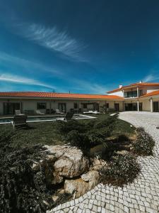 a building with a stone walkway in front of a building at Refúgio da Rainha in Moledo