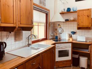 a kitchen with wooden cabinets and a sink and a stove at Damm-Kate in Zingst