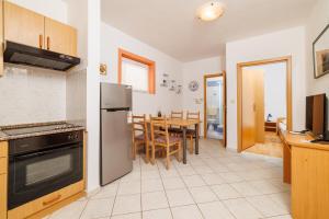 a kitchen with a stove and a dining room at Apartment Julija in Povile
