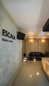 奇克拉約的住宿－ESCALA BUSINESS HOTEL，一间房间,配有床和墙上的标志