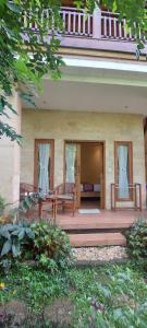 a porch of a house with a wooden deck at Jungle Joglo in Tampaksiring