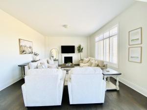 a living room with two white chairs and a table at Snow Valley Hideaway in Barrie