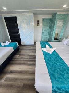um quarto com 2 camas com lençóis azuis e brancos em Hotel Zafiro Boutique em Bogotá