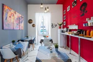 een restaurant met twee tafels en een rode muur bij Colori e Note in Napels