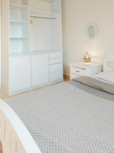 Sunny, Modern 2 bed in Makadi Heights, Hurghada في سفاجا: غرفة نوم بيضاء مع سرير ودواليب بيضاء