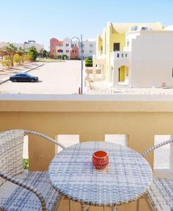 Sunny, Modern 2 bed in Makadi Heights, Hurghada في سفاجا: طاولة وكراسي على شرفة مطلة على شارع