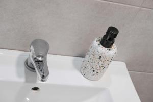 un lavabo con una botella encima en Orsiida Family apartment Volos en Volos