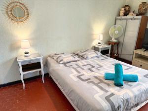 a bedroom with a bed with blue pillows on it at Maison Confort & Silence, Jardin & Barbecue in Marseille