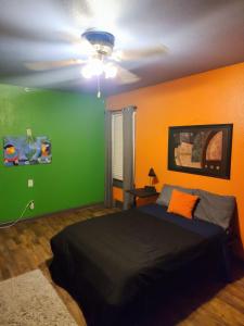 a bedroom with green and orange walls and a bed at COZY PRIVATE ROOM #2 in Dallas