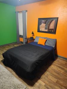 um quarto com uma cama com uma parede laranja e verde em COZY PRIVATE ROOM #2 em Dallas
