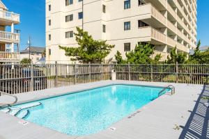 a swimming pool in front of a apartment building at Seaside Sunrise Sanctuary in Carolina Beach