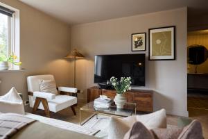 a living room with a couch and a tv at The Twickenham Wonder - Lovely 1BDR Flat with Parking in Twickenham