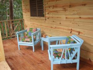 duas cadeiras sentadas num alpendre de uma cabana em Real Jamaica - Cabin right beside the sea-Papa Curvins Yard em Oracabessa