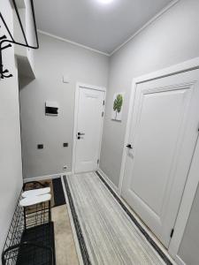 a hallway with two white doors and a rug at Diamond Apartment in Osh