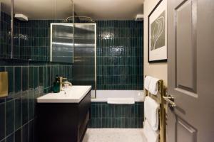 a green tiled bathroom with a sink and a tub at The Twickenham Wonder - Lovely 1BDR Flat with Parking in Twickenham