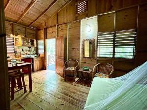 ein Wohnzimmer mit einer Hängematte in einer Hütte in der Unterkunft Real Jamaica - Cabin right beside the sea-Papa Curvins Yard in Oracabessa