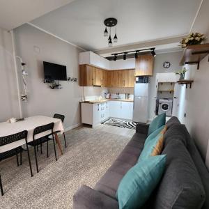 a living room with a couch and a table and a kitchen at Diamond Apartment in Osh