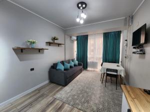 a living room with a couch and a table at Diamond Apartment in Osh