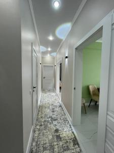 a hallway with white walls and a hallway with a carpet at Нурсултан-сити in Astana