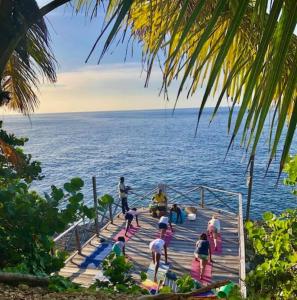 a group of people standing on a dock in the water at Real Jamaica - Cabin right beside the sea-Papa Curvins Yard in Oracabessa