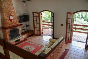 a living room with a couch and a fireplace at LINDA Chácara - IBIÚNA - Condomínio in Ibiúna