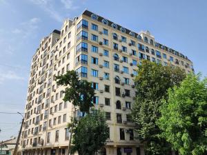 a large white building with blue windows at Diamond Apartment in Osh