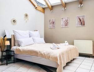 um quarto com uma cama grande e almofadas brancas em Stadtoase Fulda mit flair - Whirlpool, Balkon, 2xParkplätze, Highspeed WLAN em Fulda