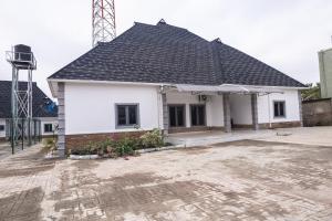 een wit huis met een zwart dak bij VETTAS APARTMENT in Akure