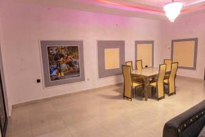 a dining room with a table and chairs at VETTAS APARTMENT in Akure
