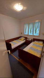duas camas num quarto com duas janelas em Domaćinstvo Jolović em Kraljevo
