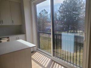 een keuken met een groot raam met uitzicht op een balkon bij Ensuite Bedroom –Double Bed: Mins from Coburg Beach in Cobourg