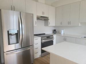 een keuken met een roestvrijstalen koelkast en een fornuis bij Ensuite Bedroom –Double Bed: Mins from Coburg Beach in Cobourg