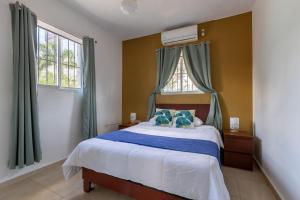 1 dormitorio con 1 cama grande con almohadas azules en EDMA APARTAHOTEL, en Santa Bárbara de Samaná