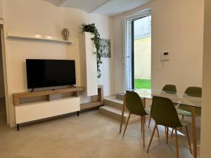 een eetkamer met een tv en een tafel en stoelen bij MONO Apartments Aldini in Bologna