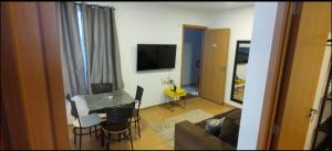 a living room with a couch and a table with chairs at Apartamento Incrivel in Campo Grande