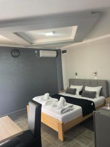 een slaapkamer met een bed met handdoeken erop bij Feher Akac Guest House in Palić